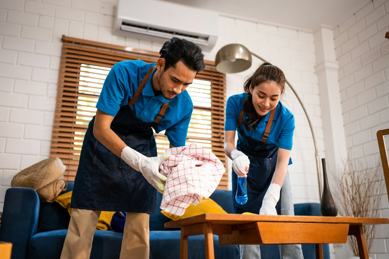 Asian young man and woman cleaning service worker work in living room. A